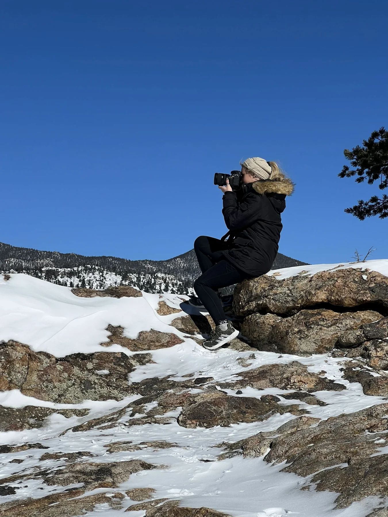 Ashley photographing from a snowy mountainside.