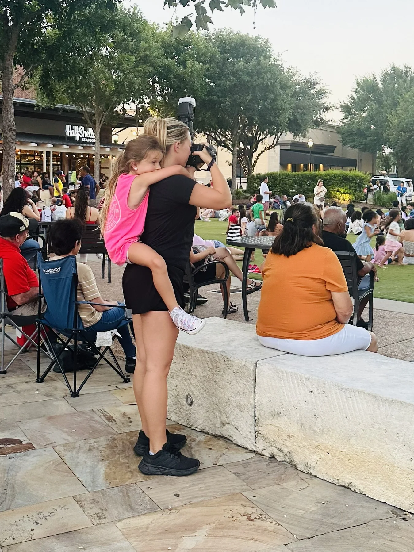 Ashley photographing while carrying her daughter on her back.