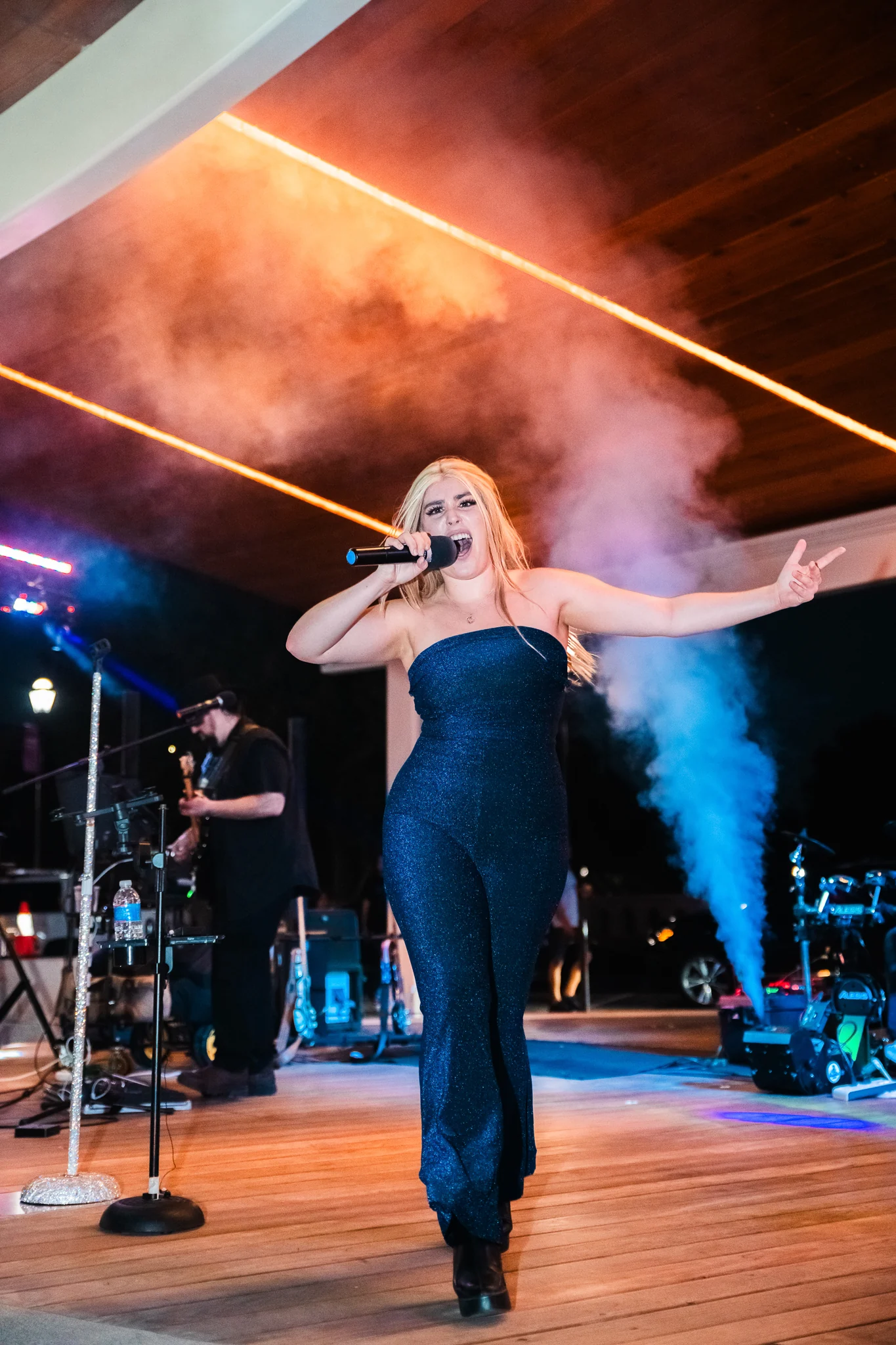 Singer performing beneath dramatic stage lights.