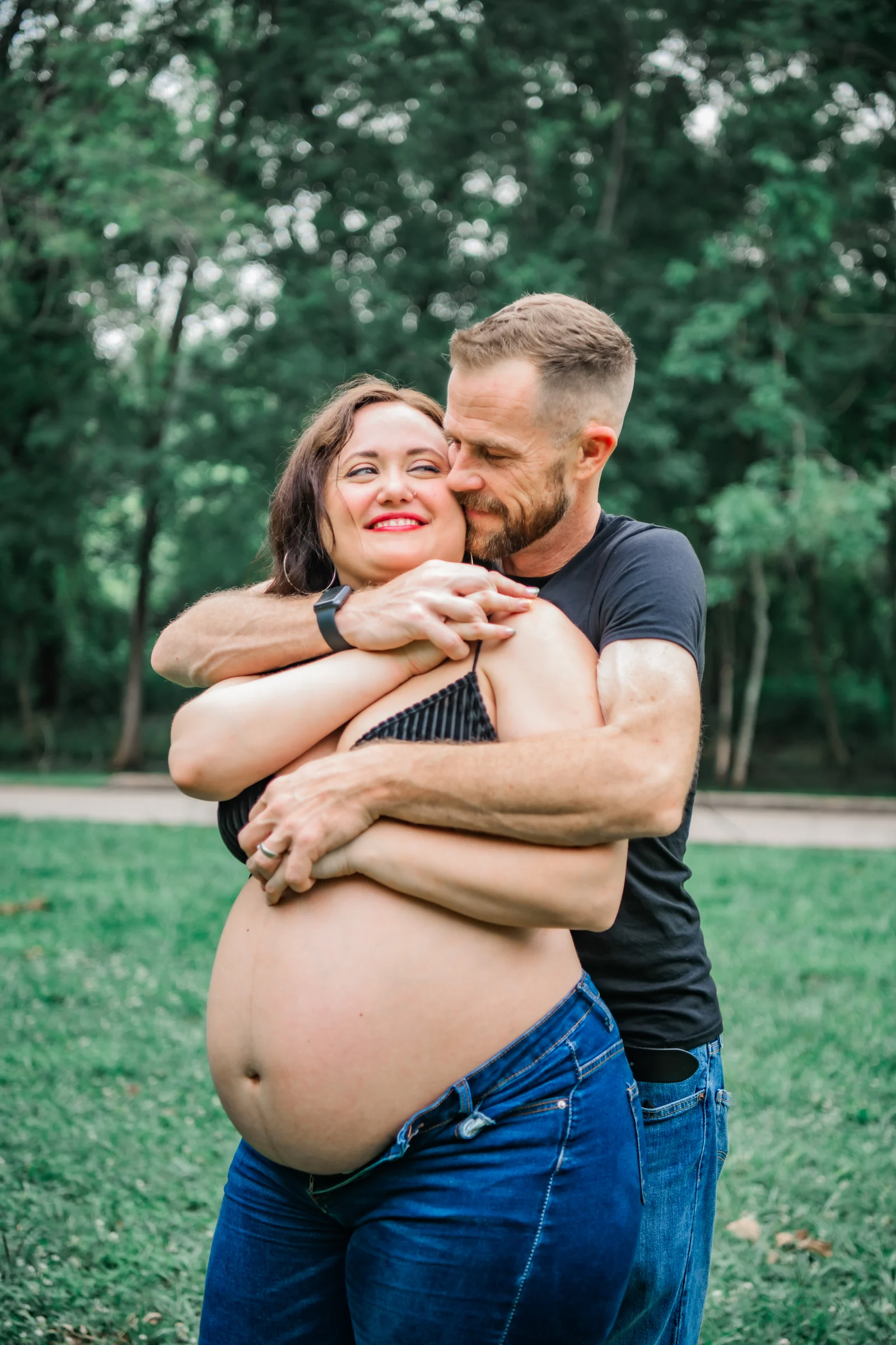 Expectant parents sharing a quiet emotional embrace.