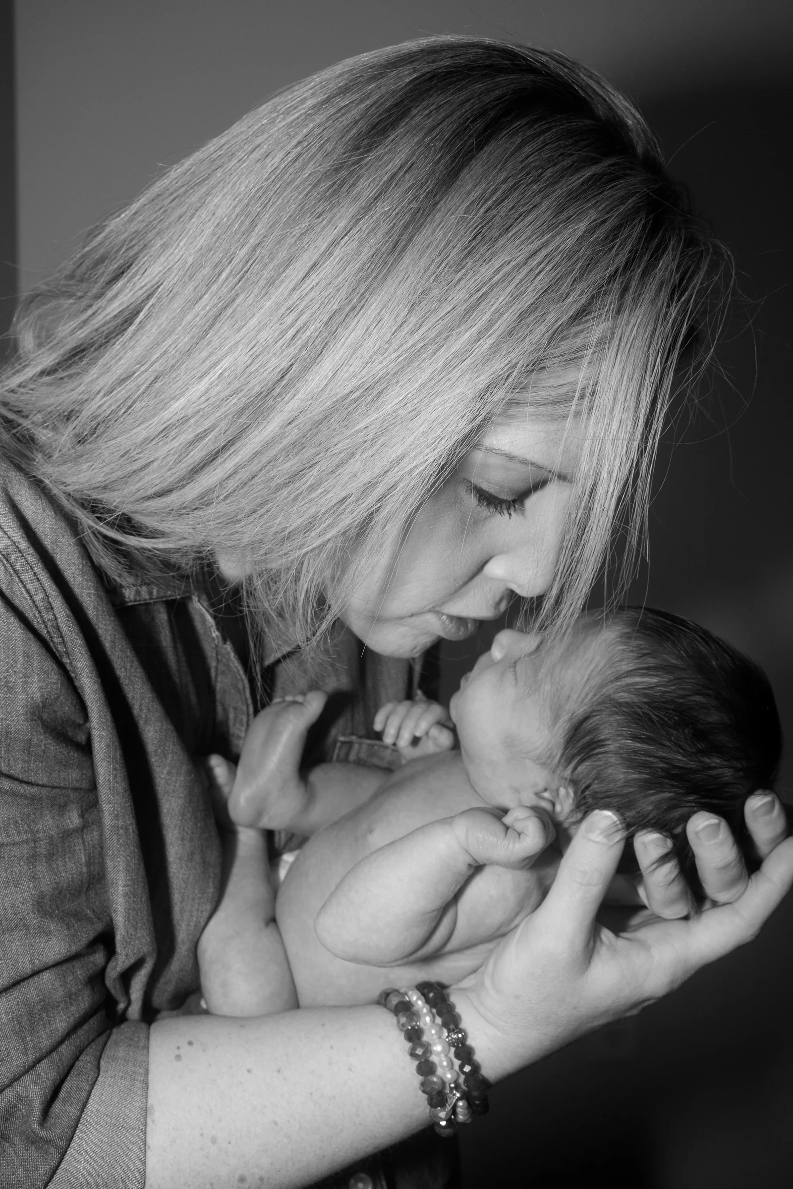 Mother gazing tenderly at her newborn in black and white.